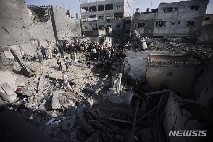 [가자지구=AP/뉴시스]팔레스타인 주민들이 12월 1일 가자지구 남부의 칸 유니스 시내 난민촌이 이스라엘의 공습으로 파괴된 자리를 살펴 보고 있다. 2023.12.03.