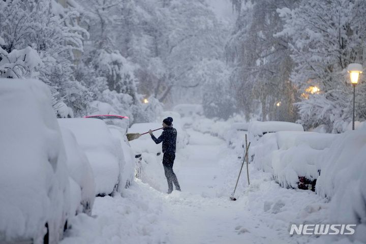 [뮌헨=AP/뉴시스] 많은 눈이 내린 2일(현지시간) 독일 뮌헨에서 한 시민이 차량에 쌓인 눈을 치우고 있다. 2023.12.04.