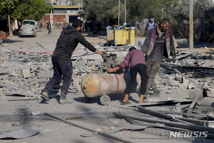 [가자지구=AP/뉴시스] 4일(현지시각) 가자지구 데이르 알발라 주민들이 이스라엘의 폭격으로 파괴된 잔해 속에서 쓸만한 물건들을 찾아 챙기고 있다. 2023.12.05.