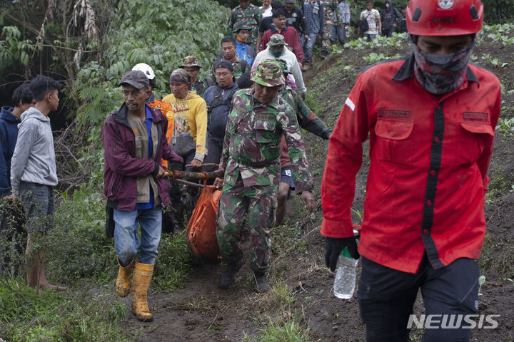 [바투 팔라노=AP/뉴시스] 5일(현지시각) 인도네시아 수마트라섬 바투 팔라노에서 구조대가 므라피 화산 폭발 희생자들의 시신을 수습해 옮기고 있다. 구조대는 등산객 11명의 시신을 추가로 발견해 지금까지 사망자 수는 22명으로 늘어났다. 2023.12.06.