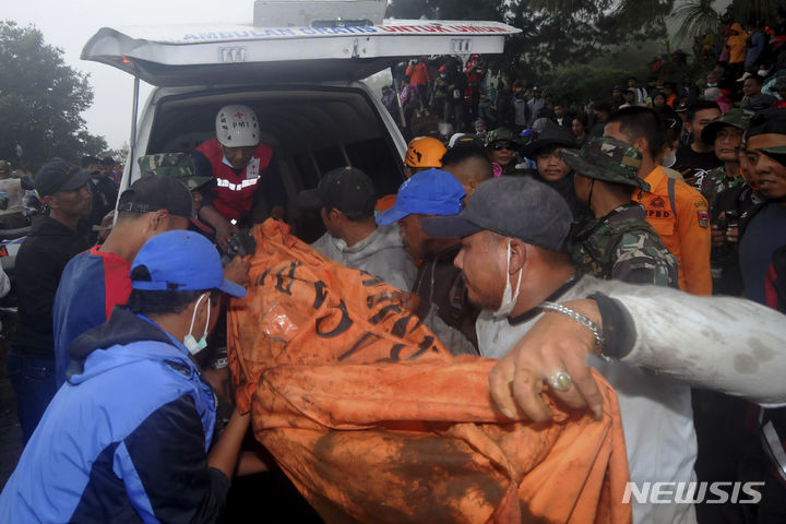 [바투 팔라노=AP/뉴시스] 5일(현지시각) 인도네시아 수마트라섬 바투 팔라노에서 구조대가 므라피 화산 폭발 희생자들의 시신을 수습해 옮기고 있다. 구조대는 등산객 11명의 시신을 추가로 발견해 지금까지 사망자 수는 22명으로 늘어났다. 2023.12.06.