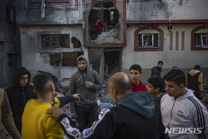 [라파=AP/뉴시스] 9일(현지시간) 가자지구 라파에서 팔레스타인 주민들이 이스라엘 폭격으로 무너진 건물을 바라보고 있다. 2023.12.10.