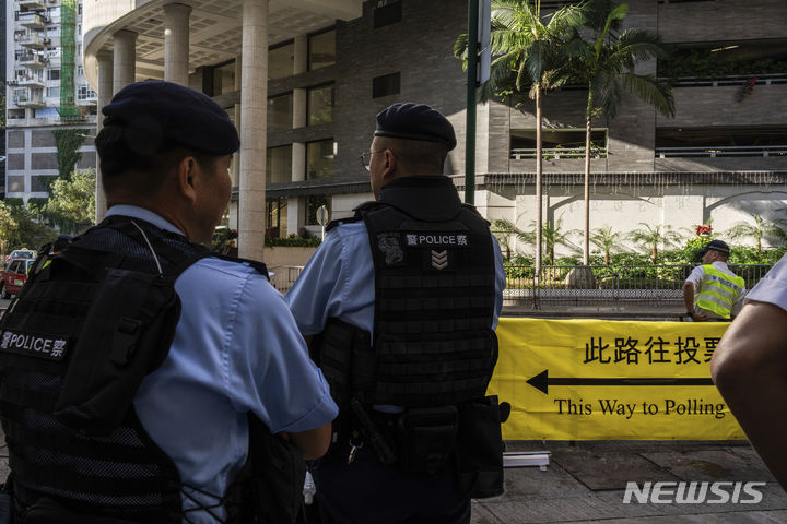 [홍콩=AP/뉴시스] 홍콩 구의원 선거가 실시되는 10일 투표소 밖에서 경찰이 순찰하고 있다. 2023.12.10.
