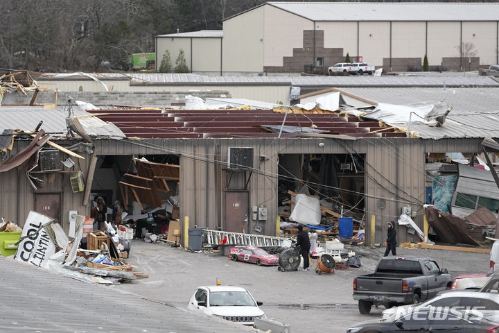 [테네시주=AP/뉴시스] 10일(현지시간) 미국 테네시주 헨더슨빌에서 주민들이 토네이도로 파손된 창고를 정리하고 있다. 2023.12.11.