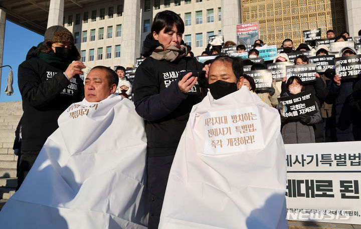 [서울=뉴시스] 이영환 기자 = 21일 오전 서울 여의도 국회 본청 앞에서 열린 전세사기 특별법 개정 촉구 기자회견에서 참석자들이 전세사기 특별법 개정을 촉구하며 삭발식을 하고 있다. 2023.12.21. 20hwan@newsis.com