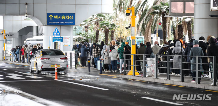 [제주=뉴시스] 우장호 기자 = 대설특보가 내려진 22일 오후 폭설로 인해 운항이 전면 중단된 제주국제공항 택시 승강장에서 이용객들이 택시를 기다리고 있다. 2023.12.22. woo1223@newsis.com