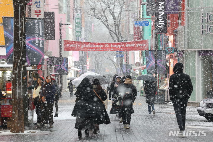 [서울=뉴시스] 최진석 기자 = 서울 전역에 눈이 내리고 있는 30일 서울 중구 명동 거리에서 시민들이 내리는 눈을 맞으며 발걸음을 재촉하고 있다. 2023.12.30. myjs@newsis.com