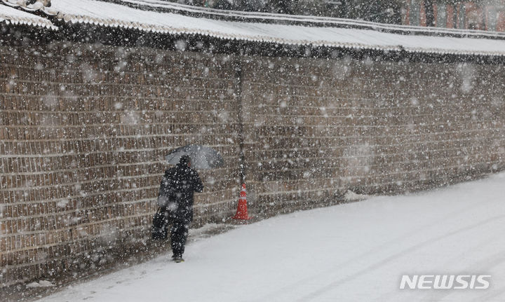 [서울=뉴시스] 김근수 기자 = 수요일인 3일은 전국 대부분 지역에 비 또는 눈이 내리겠다. 사진은 지난달 30일 서울 종로구 세종대로 일대에서 한 시민이 우산을 쓰고 지나가고 있는 모습. 2023.12.30. ks@newsis.com
