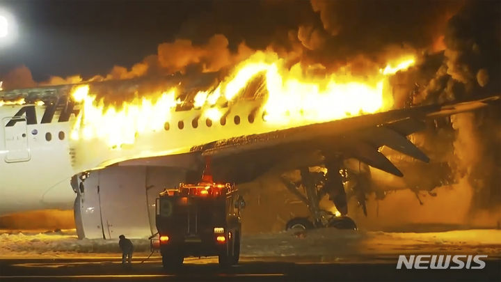 [도쿄=AP/뉴시스] 2일(현지시각) 일본 도쿄 하네다 공항 활주로에 착륙하던 일본항공(JAL) 항공기가 불길에 휩싸여 있다. 2024.01.02.