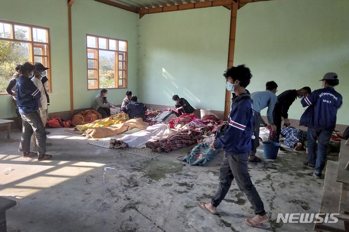 [까난=AP/뉴시스] 7일(현지시각) 미얀마 북서부 사가잉주 캄빳 지역 까난 마을 주민들이 미얀마군의 공습으로 희생된 사람들의 시신을 담요로 덮고 있다. 이 공습으로 어린이 9명 포함 최소 17명이 숨지고 20여 명이 다친 것으로 알려졌다. 2024.01.08.