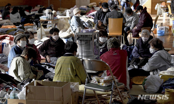[이시카와=AP/뉴시스]일본 이시카와현 아나미즈의 노토지진 피난소에서 지난 8일 피난 주민들이 모여 난로를 쬐고 있다. 2024.01.09.