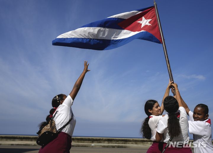 [아바나=AP/뉴시스] 8일(현지시각) 쿠바 아바나에서 학생들이 피델 카스트로가 이끄는 혁명군 수도 입성 제65주년 기념 퍼레이드를 환영하며 국기를 흔들고 있다. 카스트로는 1959년 1월 8일 혁명군을 이끌고 수도에 입성해 친미 독재 정권을 몰아내는 쿠바 혁명에 마침표를 찍었다. 2024.01.09.