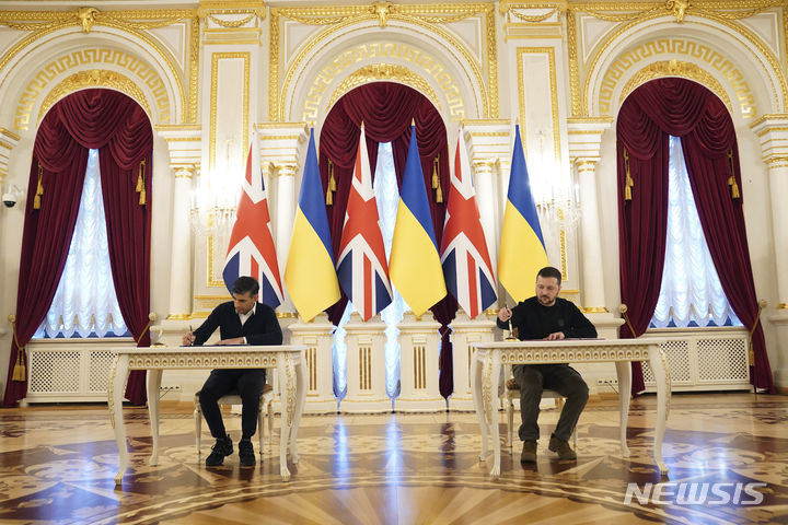 [키이우=AP/뉴시스] 지난 12일 볼로디미르 젤렌스키(오른쪽) 우크라이나 대통령과 리시 수낵 영국 총리가 키이우에서 안보 협정서에 서명하고 있다. 2024.01.13.