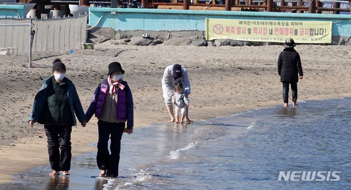 [제주=뉴시스] 오영재 기자 = 평년보다 높은 16~17도의 낮 기온을 보인 14일 오전 제주 이호테우해수욕장에서 도민과 관광객들이 맨발로 해변을 걷는 '어싱'을 하고 있다. 2024.01.14. photo@newsis.com