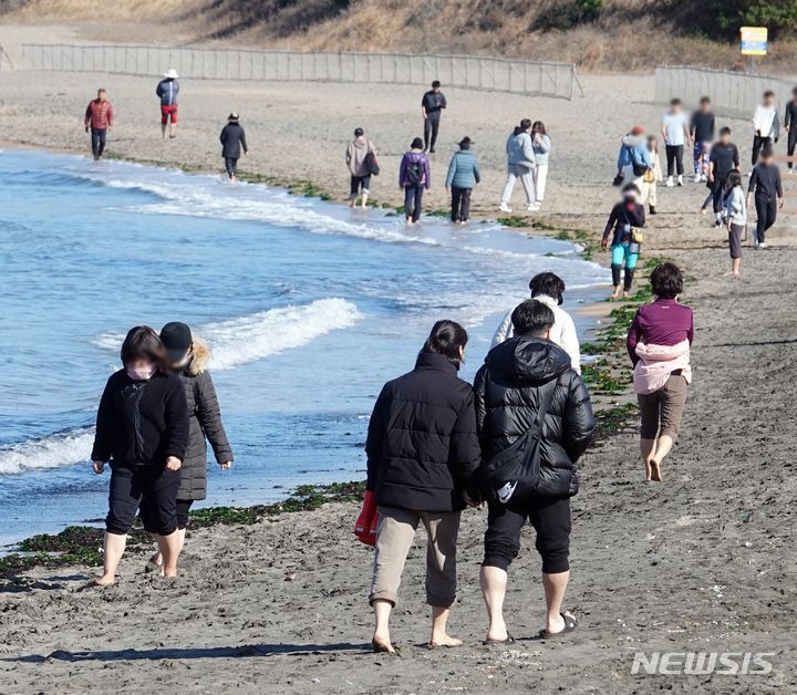 [제주=뉴시스] 오영재 기자 = 평년보다 높은 16~17도의 낮 기온을 보인 14일 오전 제주 이호테우해수욕장에서 도민과 관광객들이 맨발로 걷는 '어싱' 활동을 하고 있다. 2024.01.14. photo@newsis.com 