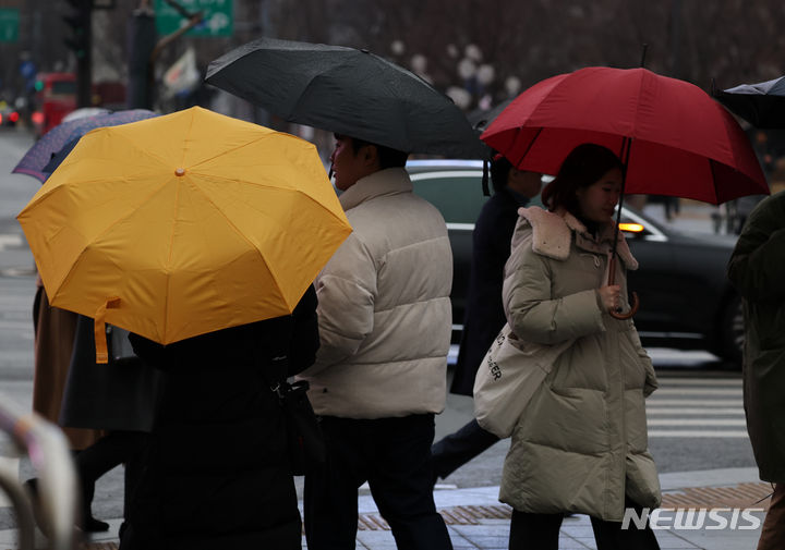 [서울=뉴시스] 배훈식 기자 = 서울 종로구 광화문 광장에서 우산을 쓴 사람들이 걸어가고 있다. 2024.01.14. dahora83@newsis.com