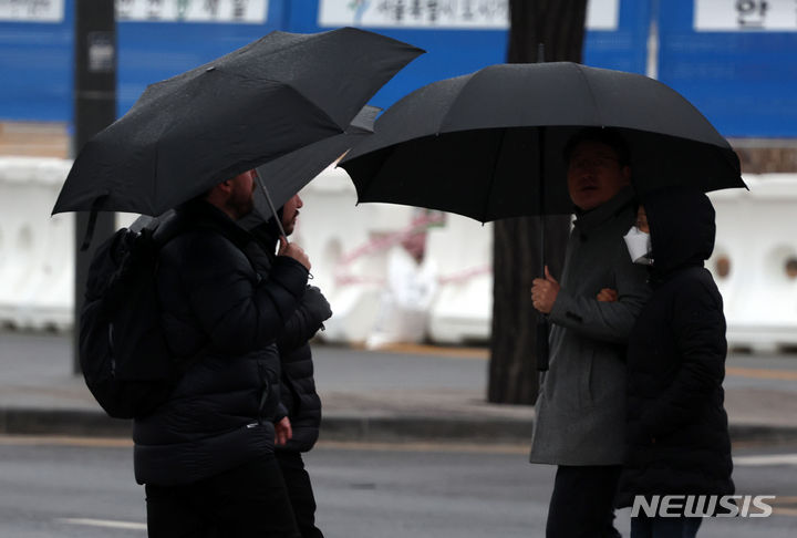 [서울=뉴시스] 배훈식 기자 = 전국 대부분 지역에 눈과 비가 내린 지난 14일 오전 서울 종로구 광화문 광장에서 우산을 쓴 사람들이 걸어가고 있다. 2024.01.14. dahora83@newsis.com