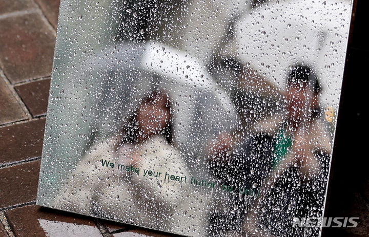 [대구=뉴시스] 이무열 기자 = 비가 내리는 18일 대구 중구 동성로에서 시민들이 우산을 쓰고 이동하고 있다. 2024.01.18. lmy@newsis.com