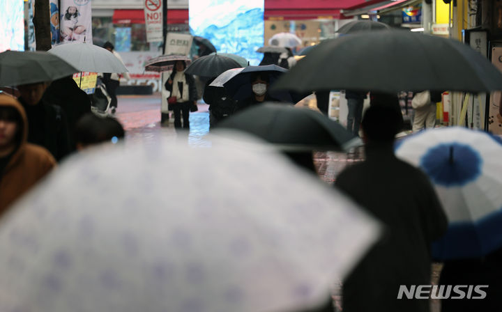 [대구=뉴시스] 이무열 기자 = 비가 내리는 18일 대구 중구 동성로에서 시민들이 우산을 쓰고 이동하고 있다. 2024.01.18. lmy@newsis.com