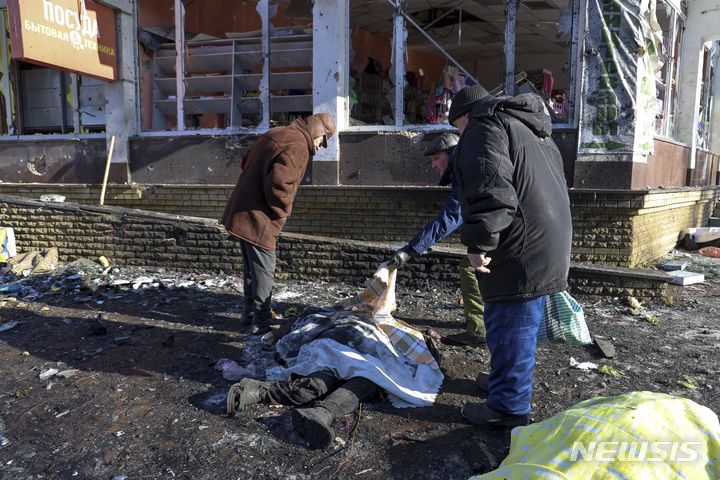 [텍스틸시크=AP/뉴시스] 21일(현지시각) 러시아 점령지인 우크라이나의 분리주의 도네츠크인민공화국(DPR)의 텍스틸시크에서 주민들이 포격에 숨진 희생자 시신을 확인하고 있다. 러시아는 우크라군의 공격으로 28명이 사망하고 30명이 부상했다면서 "야만적인 테러 행위"라고 비난했다. 2024.01.22.
