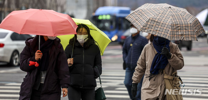 [서울=뉴시스] 정병혁 기자 = 지난달 21일 서울 세종대로에서 우산을 쓴 시민들이 이동하고 있다. 2024.01.21. jhope@newsis.com