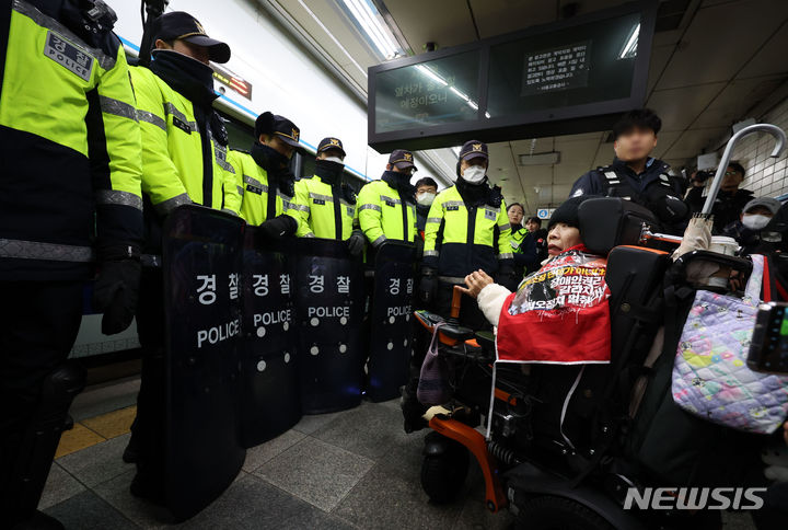 [서울=뉴시스] 김선웅 기자 = 전국장애인차별철폐연대 회원들이 22일 서울 지하철 4호선 혜화역에서 장애인 이동권 보장을 촉구하고 있다. 2024.01.22. mangusta@newsis.com