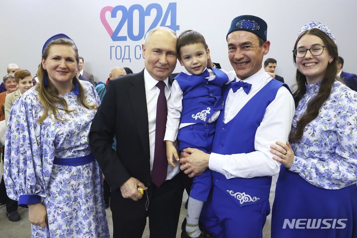 [모스크바=AP/뉴시스] 블라디미르 푸틴(가운데) 러시아 대통령이 23일(현지시각) 모스크바의 구 러시아 박람회장(VDNKh)에서 열린 러시아 가족 가치 포럼 '가족과 사랑하는 사람들'에 참석해 참가자들과 기념 촬영을 하고 있다. 2024.01.24.