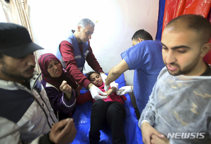 [칸유니스=AP/뉴시스] 1월24일 가자지구 칸유니스에서 팔레스타인 의료진이 이스라엘의 유엔 팔레스타인 난민구호기구(UNRWA) 교육센터 건물 전차 공격으로 다친 소녀를 치료하고 있다. 현지 관계자는 난민들의 피난처로 사용되는 UNRWA 건물에 이스라엘 전차가 포격을 가해 최소 9명이 숨지고 75명이 다쳤다고 밝혔다. 2024.05.10.