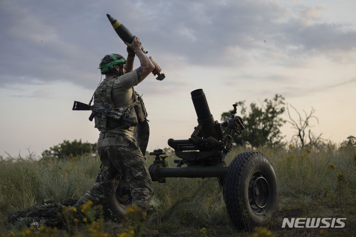 [AP/뉴시스] 2023년 7월 우크라이나 병사가 동부 바크무트 전선에서 러시아 진지를 향해 122㎜ 박격포를 쏠 준비을 하고 있다. 