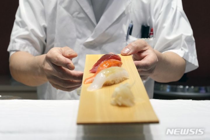 A cook prepares a sushi dish at a restaurant at "Toyosu Senkyaku Banrai," an Edo Period-themed hot spring complex on media preview event at Toyosu Market Monday, Jan. 29, 2024, in Tokyo. (AP Photo/Eugene Hoshiko) (사진과 기사는 무관함)