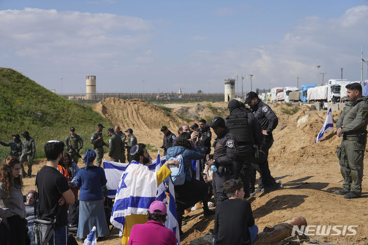 [케렘 샬롬=AP/뉴시스]지난 1월29일 이스라엘 경찰이 이스라엘 남부 케렘 샬롬 국경에서 인도주의적 지원 물품을 실은 트럭의 진입에 반대하는 시위대와 대치하고 있다. 이스라엘 시위대 수십명이 16일(현지시각) 요르단강 서안에서 구호품을 싣고 가자지구로 향하던 트럭을 공격, 운전기사를 구타하고 가자지구로의 구호품 전달을 가로막았다. 2024.05.17.