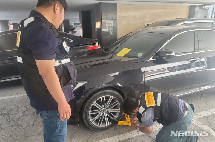 [안산=뉴시스] 안산시 고액체납자 전담반이 고액상습체납자의 차량에 족쇄를 채우고 있다.(사진=안산시 제공) 2024.02.05.photo@newsis.com