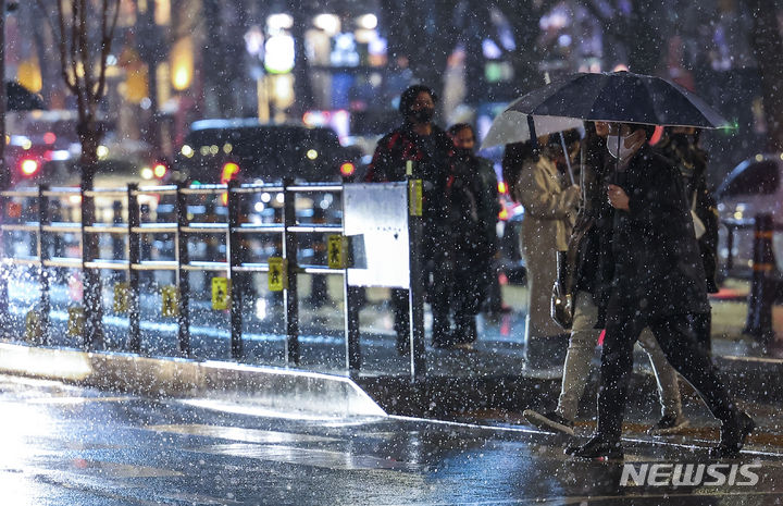 [서울=뉴시스] 정병혁 기자 = 눈이 내린 지난 5일 서울 종로구 광화문사거리에서 우산을 쓴 시민들이 이동하고 있다. 2024.02.05. jhope@newsis.com