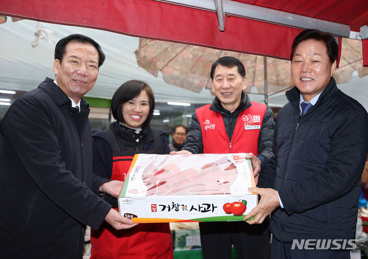 [창원=뉴시스]6일 경남 거창군 거창전통시장을 찾은 박완수(맨 오른쪽) 도지사가 온누리상품권으로 거창한 사과를 구매하고 있다.(사진=경남도 제공)2024.02.06. photo@newsis.com