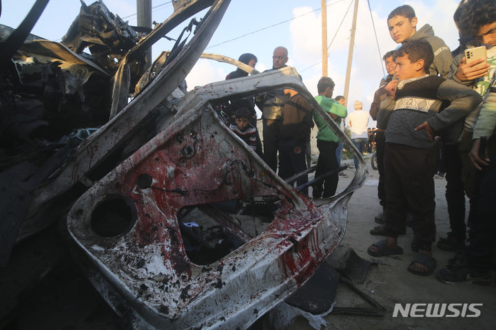 [라파=AP/뉴시스] ﻿﻿이스라엘군이 12일(현지시간) 가자지구 최남단 도시 라파 일대를 타격한 가운데 팔레스타인 무장정파 하마스는 최소 52명이 사망했다고 밝혔다. 사진은 지난 6일 가자지구 라파에서 팔레스타인인들이 이스라엘의 공습을 받은 하마스 경찰 차량 잔해 주변에 모여 있는 모습. 2024.02.12