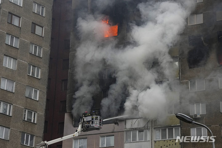 [키이우=AP/뉴시스] 7일(현지시각) 우크라이나 키이우에서 소방관들이 러시아군의 공습으로 불타는 아파트 화재를 진압하고 있다. 현지 당국은 러시아가 우크라이나 전역을 겨냥해 미사일과 드론 등을 발사해 최소 5명이 숨지고 40여 명이 다쳤다고 밝혔다. 2024.02.08