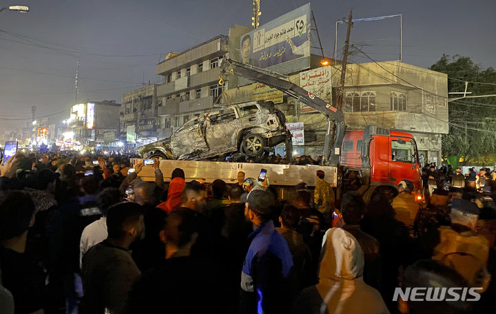 [바그다드=AP/뉴시스] 미국이 7일(현지시간) 요르단 주둔 자국군 병사 사망에 대한 보복으로 바그다드를 공습해 카타이브 헤즈볼라 고위 지휘관이 사망한 가운데 이라크는이번 공습이 미국의 침략 행위라고 반발했다. 사진은 이날 이라크 수도 바그다드에서 이라크 사람들이 미군의 드론 공격으로 불에 탄 차량 주변에 모여 있는 모습. 2024.02.08.