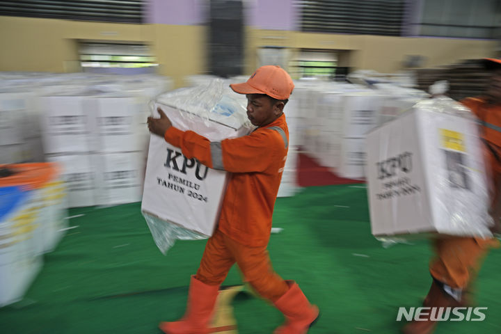 [자카르타=AP/뉴시스] 인도네시아 대선과 총선을 하루 앞둔 13일(현지시각) 자카르타의 한 체육관에서 인부들이 각 투표소로 보낼 투표함을 나르고 있다. 2024.02.13.
