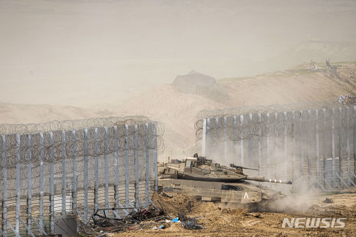 [가자지구=AP/뉴시스] 13일(현지시각) 이스라엘군 전차 한 대가 이스라엘 남부에서 국경을 넘어 가자지구로 진입하고 있다. 2024.02.14.