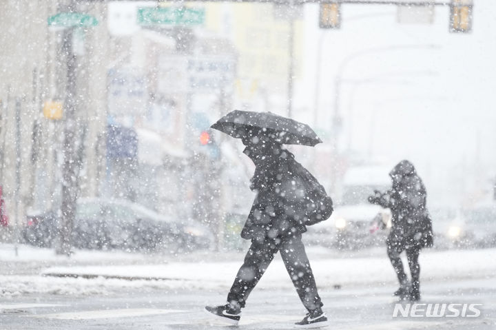 [필라델피아=AP/뉴시스] 많은 눈이 내린 13일(현지시간) 미국 필라델피아에서 시민들이 발걸음을 옮기고 있다. 2024.02.14.