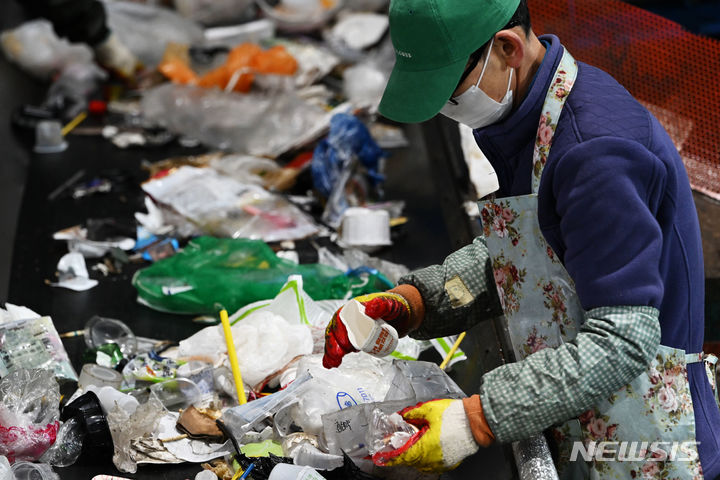 [광주=뉴시스] 이영주 기자 = 13일 오전 광주 북구 월출동 한 재활용품 선별장에서 작업자들이 설 연휴 당시 배출된 재활용품 쓰레기 봉투에 든 쓰레기들을 일반쓰레기와 재활용품으로 분류하고 있다. 2024.02.13 leeyj2578@newsis.com