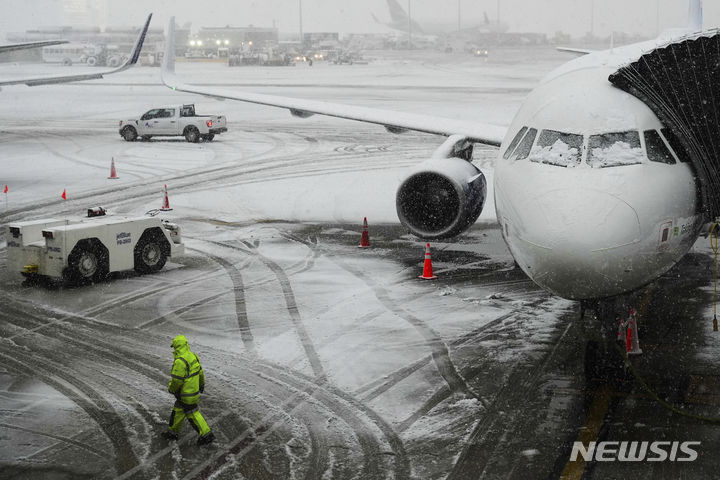 [뉴욕=AP/뉴시스] 많은 눈이 내린 13일(현지시간) 미국 뉴욕 존 F. 케네디 국제공항 활주로에 비행기가 서 있다. 2024.02.14.