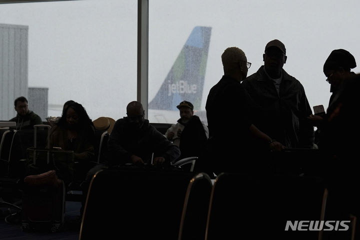 [뉴욕=AP/뉴시스] 많은 눈이 내린 13일(현지시간) 미국 뉴욕 존 F. 케네디 국제공항에서 승객들이 비행기 탑승을 위해 대기하고 있다. 2024.02.14.