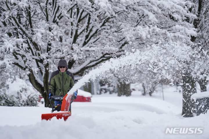 [펜실베니아=AP/뉴시스] 많은 눈이 내린 13일(현지시간) 미국 펜실베니아에서 한 시민이 제설 작업을 하고 있다. 2024.02.14.