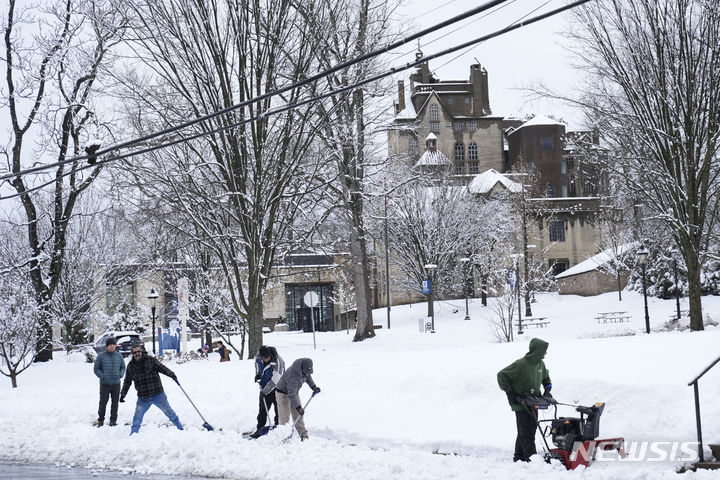[펜실베니아=AP/뉴시스] 많은 눈이 내린 13일(현지시간) 미국 펜실베니아주 도일스타운에서 시민들이 제설 작업을 하고 있다. 2024.02.14.