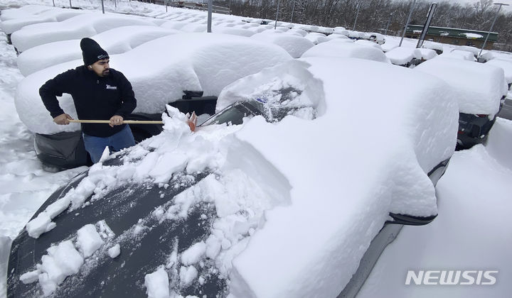 [펜실베니아=AP/뉴시스] 많은 눈이 내린 13일(현지시간) 미국 펜실베니아주에서 한 시민이 차량에 쌓인 눈을 치우고 있다. 2024.02.14.