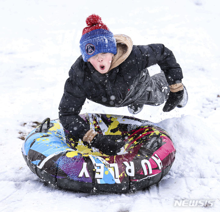 [매사추세츠=AP/뉴시스] 많은 눈이 내린 13일(현지시간) 미국 매사추세츠주에서 한 어린이가 썰매를 타고 있다. 2024.02.14.