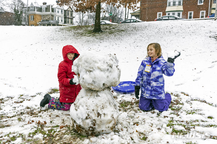 [펜실베니아=AP/뉴시스] 많은 눈이 내린 13일(현지시간) 미국 펜실베니아주 필라델피아에서 어린이들이 눈사람을 만들고 있다. 2024.02.14.