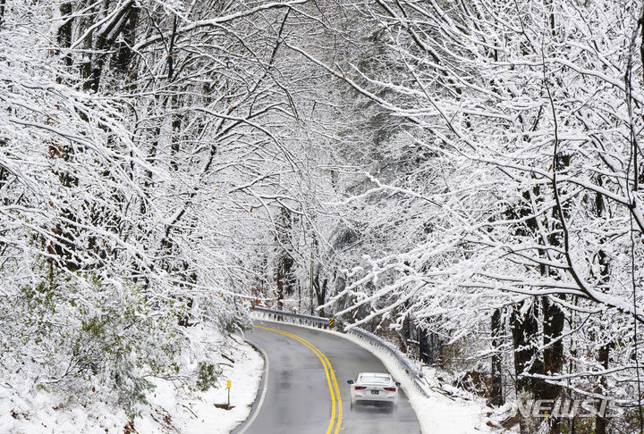[메릴랜드=AP/뉴시스] 많은 눈이 내린 13일(현지시간) 미국 메릴랜드주 프레드릭 카운티에서 차량이 서행하고 있다. 2024.02.14.