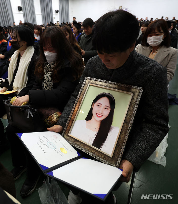 [서울=뉴시스] 김선웅 기자 = 15일 서울 구로구 성공회대학교에서 열린 학위수여식에서 이태원 참사로 유명을 달리한 故 진세은 학생의 유족이 명예학위증을 바라보고 있다. 2024.02.15. mangusta@newsis.com